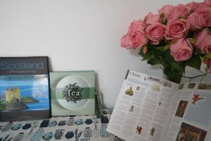 a table with a vase of pink roses and papers at Campbell Loft 1BR 1B in Campbell