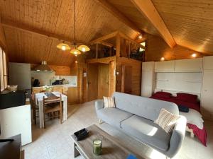 un soggiorno con un divano e un tavolo in una stanza di Chalet avec Clim, Wi-Fi et Animaux Acceptés à Saint-Bonnet-Tronçais - FR-1-489-445 a Saint-Bonnet-Tronçais Altre 7 foto