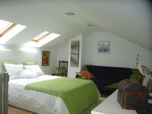 a bedroom with a green bed and a couch at Casa do Terreiro in Beiral do Lima