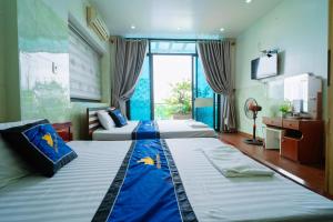 a hotel room with two beds and a television at Điêu Thuyền Motel 199VTK in An Khê