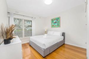 Un dormitorio blanco con una cama y una ventana. en Hawthorn's Hidden Gem With Free WiFi & Carparking, en Melbourne 1 foto más