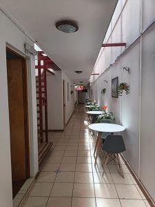 un pasillo con mesas y sillas en un edificio en Lodge Atacama Hostal, en Copiapó