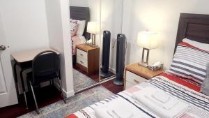 una camera da letto con un letto, una scrivania e uno specchio di Two luxury bedrooms in the basement a Winnipeg