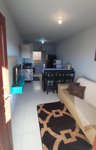 a living room with a couch and a kitchen at Residencial Fênix II in Florianópolis