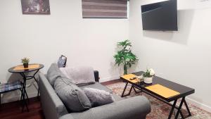 a living room with a couch and a table at Two luxury bedrooms in the basement in Winnipeg