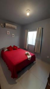 a red bed in a room with a window at Residencial Fênix II in Florianópolis