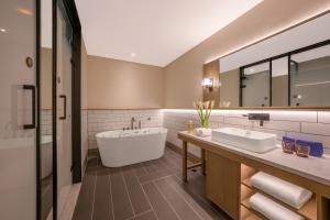 a bathroom with a tub and a large mirror at 武汉汉口金融中心万象城漫心酒店 in Wuhan