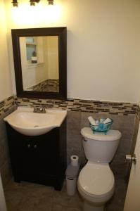 Un baño con lavabo, inodoro y espejo. en Beach House, en Largo 19 fotos más