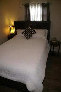 1 dormitorio con cama blanca y almohada en Beach House, en Largo