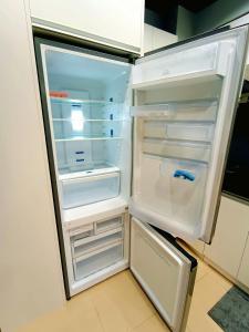an empty refrigerator with its door open in a kitchen at 1205T2 Avida Riala IT Park 1BR Unit 400Mbps Internet in Cebu City