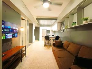 a living room with a couch and a flat screen tv at 1205T2 Avida Riala IT Park 1BR Unit 400Mbps Internet in Cebu City