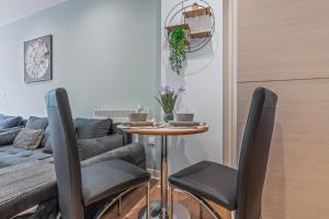 a table and chairs in a living room with a couch at Spacious Central Leeds Flat - Sleeps 8 - View City Centre in Central Station