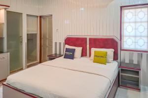 Postel nebo postele na pokoji v ubytování Urbanview Hotel Executive Residence Semarang by RedDoorz