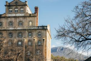 a building with a sign on the side of it at Rivulet Retreat - Cosy South Hobart Home & Parking in West Hobart