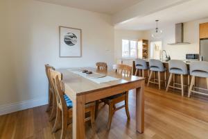 a kitchen and dining room with a wooden table and chairs at Rivulet Retreat - Cosy South Hobart Home & Parking in West Hobart