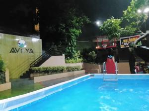 ein Pool bei Nacht mit einem Basketballkorb in der Unterkunft AVEYA Staycation in Tanay