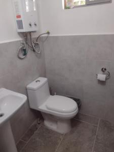 a bathroom with a white toilet and a sink at Céntrico y accesible in Ciudad Juárez