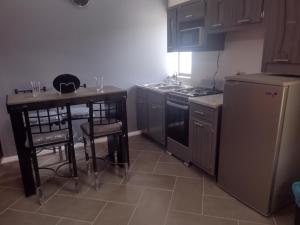 a kitchen with a table and a stove and a refrigerator at Céntrico y accesible in Ciudad Juárez