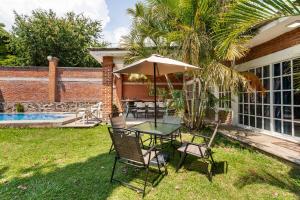 a table and chairs with an umbrella in the yard at Casa Gume in Yautepec