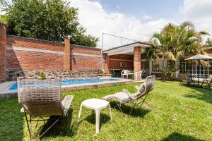 Eine Gruppe von Stühlen und ein Tisch in einem Garten in der Unterkunft Casa Gume in Yautepec de Zaragoza