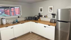 a kitchen with white cabinets and a stainless steel refrigerator at Supinder's Rentals in Golden