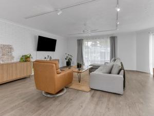 a living room with a couch and a chair at Ultimate Beachside Haven in Cabarita - Pet Friendly in Cabarita Beach