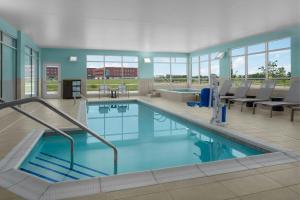 a large swimming pool with blue water in a building at SpringHill Suites by Marriott Grand Island in Grand Island