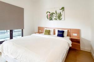 a bedroom with a large white bed with blue pillows at Urbanview Hotel Syariah Nawasena Guest House IKN by RedDoorz in Sepaku