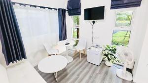a living room with white furniture and a window at The Snow Cottages in Pakha
