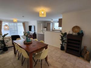 a kitchen and living room with a wooden table and chairs at Cape View 26 Your Perfect Coastal Retreat in Broadwater