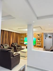 a living room with leather furniture and a television at newtown apartment olaleye iporin surulere nigeria in Iponri +2 photos