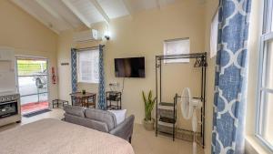 una camera da letto con un letto, un divano e una TV di Country Rest - 8 min Drive from UVF Airport a Vieux Fort