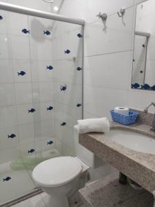 a white bathroom with a toilet and a shower at Residencial Prais Dos Corais H106 in Santa Cruz Cabrália