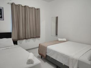 a room with two beds and a window at Residencial Prais Dos Corais H106 in Santa Cruz Cabrália