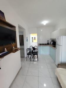 a kitchen with a table and chairs and a refrigerator at Residencial Prais Dos Corais H106 in Santa Cruz Cabrália