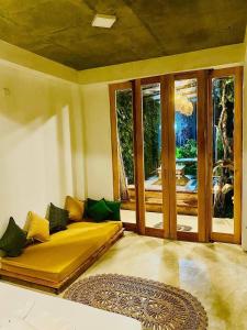 a bedroom with a yellow bed and a large window at Sesatha waters edge villa in Tangalle