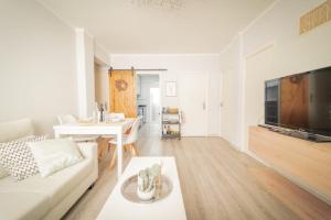 a living room with a white couch and a tv at Apartamento cerca zona comercial in Narón