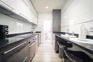 a large kitchen with two sinks and a counter at Apartamento cerca zona comercial in Narón +5 photos