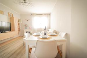 a white dining room with a white table and chairs at Apartamento cerca zona comercial in Narón