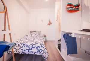 a bedroom with a bed with a blue and white comforter at Apartamento cerca zona comercial in Narón