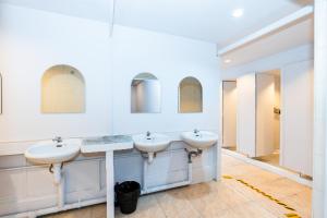 a bathroom with two sinks and two mirrors at The Hidden Khaosan - เดอะ ฮิดเด้นข้าวสาร in Bang Bua Thong Railway Station