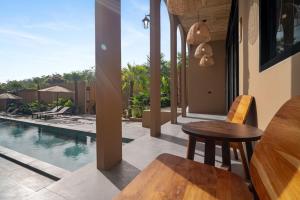 a dining room with a table and a swimming pool at The Wood Terrace in Ban Chin Tham Mai