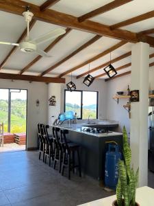 a kitchen with a counter with a stove and chairs at Villa Amore in El Peñol
