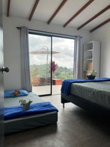 a bedroom with two beds and a large window at Villa Amore in El Peñol