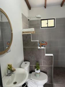 a bathroom with a sink and a toilet and a mirror at Villa Amore in El Peñol +35 photos