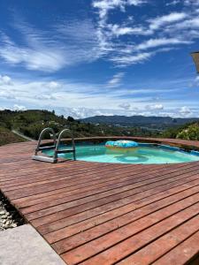 a swimming pool on a wooden deck with a slide at Villa Amore in El Peñol