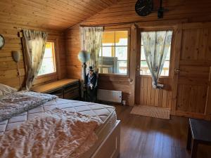 a bedroom with a bed in a wooden room at Luxury Holiday Home with Private Lake in Vehmaa