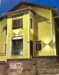 a yellow house with graffiti on the side of it at Villa Olas y Llamas in Santander