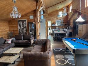 a living room with a pool table in a cabin at Luxury Holiday Home with Private Lake in Vehmaa