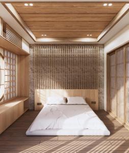 ein Schlafzimmer mit einem großen weißen Bett in einem Zimmer in der Unterkunft Amani Suites Yogyakarta in Timuran